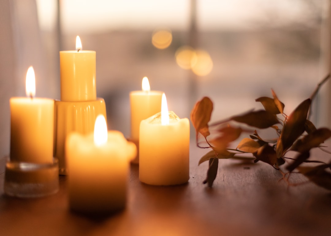 Sfeervolle kaarsen met herfstgeur op een tafel.
